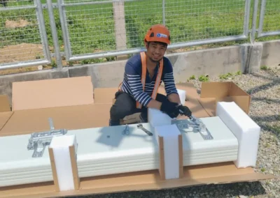 Worker preparing white equipment components outdoors