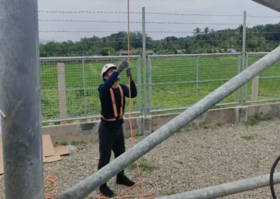 Worker standing beside the support structure of a telecom tower