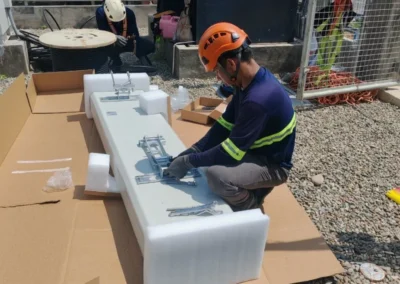 Worker assembling a white equipment component outdoors